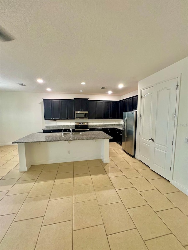 3333 Wauseon Dr, Saint Cloud, FL 34772 - kitchen with appliances with stainless steel finishes, dark cabinetry, light stone countertops, light tile patterned floors, and recessed lighting