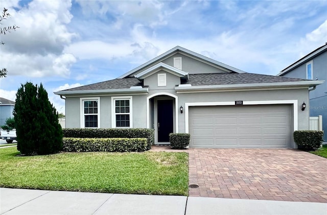 3333 Wauseon Dr, Saint Cloud, FL 34772 - view of front of property featuring stucco siding, decorative driveway, a front yard, an attached garage, and a shingled roof