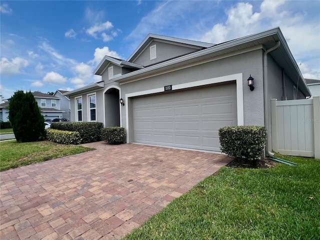 3333 Wauseon Dr, Saint Cloud, FL 34772 - view of front of house featuring stucco siding, decorative driveway, and an attached garage