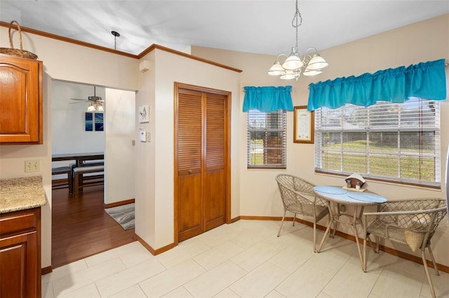 tiled dining space featuring ceiling fan with notable chandelier