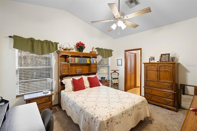 carpeted bedroom with ceiling fan, a closet, and vaulted ceiling