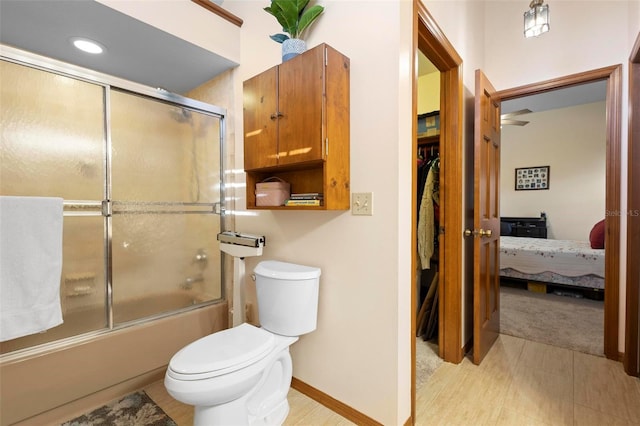 bathroom featuring shower / bath combination with glass door and toilet