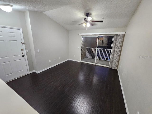 interior space with ceiling fan, dark hardwood / wood-style flooring, lofted ceiling, and a textured ceiling