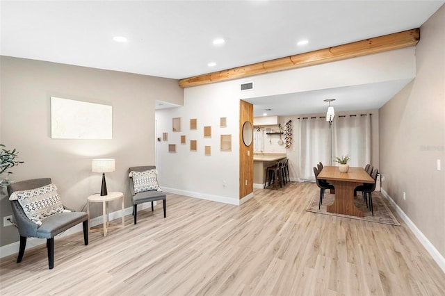 living area with beam ceiling and light hardwood / wood-style flooring