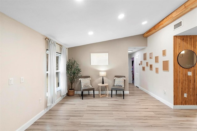 living area with vaulted ceiling with beams and light hardwood / wood-style flooring