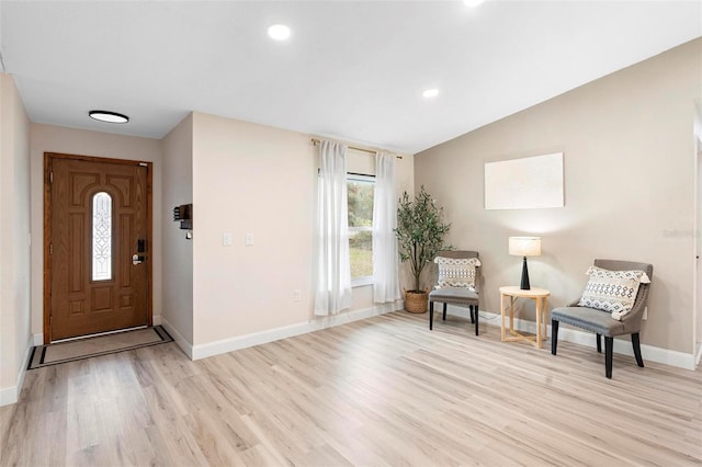 foyer entrance with light hardwood / wood-style floors and vaulted ceiling