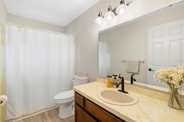 bathroom with toilet, vanity, and hardwood / wood-style floors