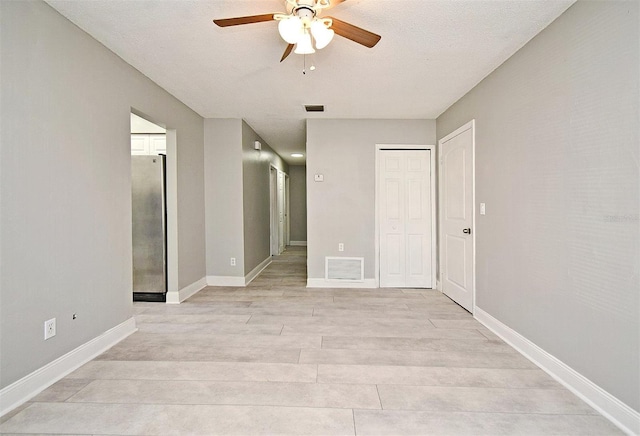 unfurnished room featuring ceiling fan, light hardwood / wood-style floors, and a textured ceiling