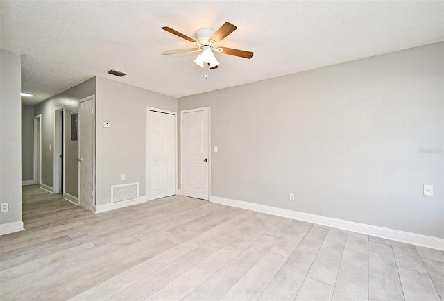 spare room featuring a textured ceiling, light hardwood / wood-style flooring, and ceiling fan