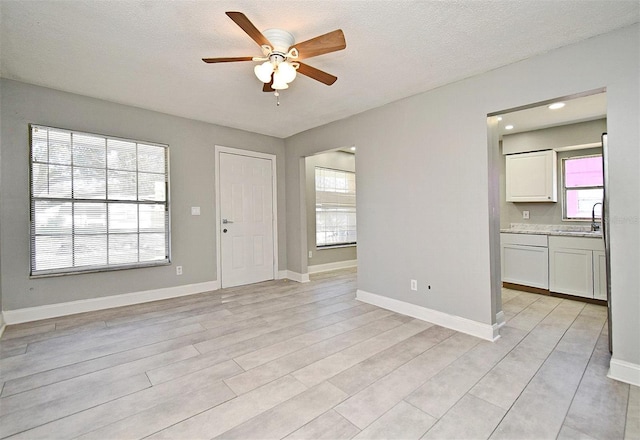 interior space featuring a textured ceiling, ceiling fan, and sink