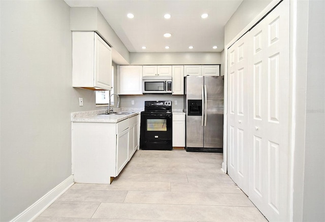 kitchen featuring stainless steel fridge, white cabinetry, black electric range oven, and sink