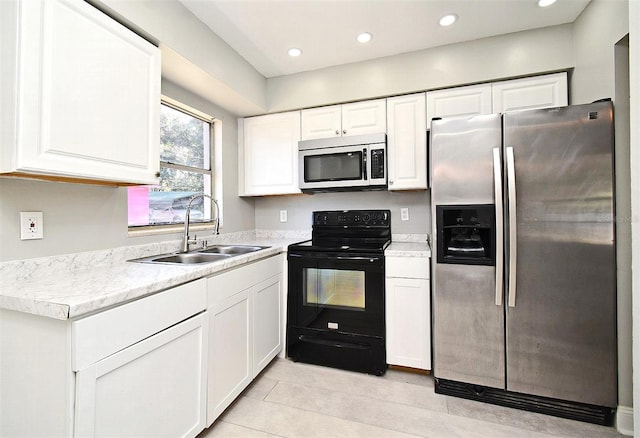 kitchen featuring white cabinetry, stainless steel fridge, and black range with electric cooktop