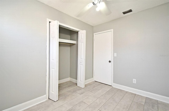 unfurnished bedroom featuring a textured ceiling, a closet, and ceiling fan