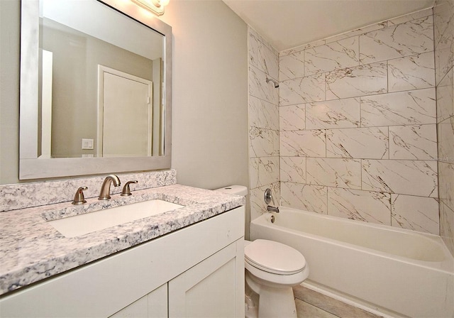 full bathroom featuring tile patterned floors, toilet, vanity, and tiled shower / bath