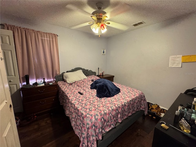 bedroom with ceiling fan, dark hardwood / wood-style floors, and a textured ceiling