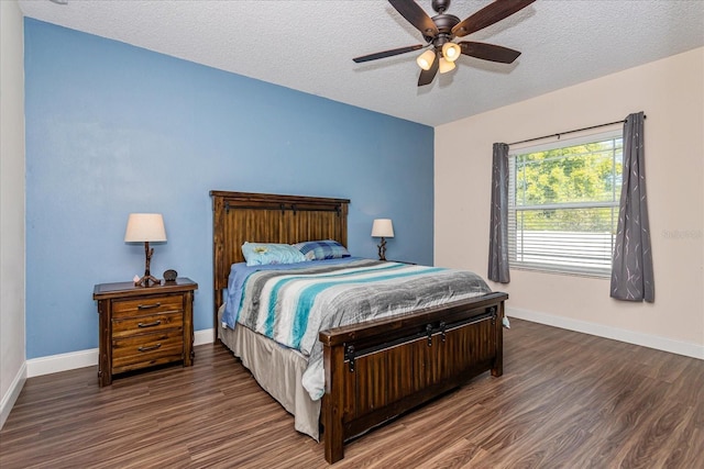 bedroom featuring ceiling fan, dark wood-type flooring, and a textured ceiling