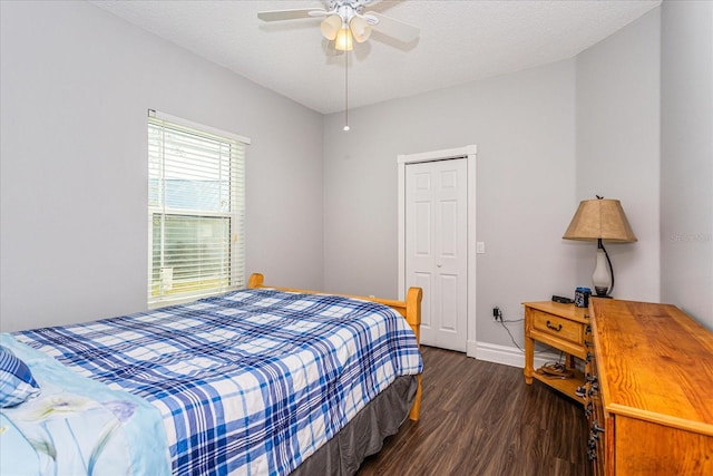 bedroom featuring a textured ceiling, ceiling fan, a closet, and dark hardwood / wood-style floors