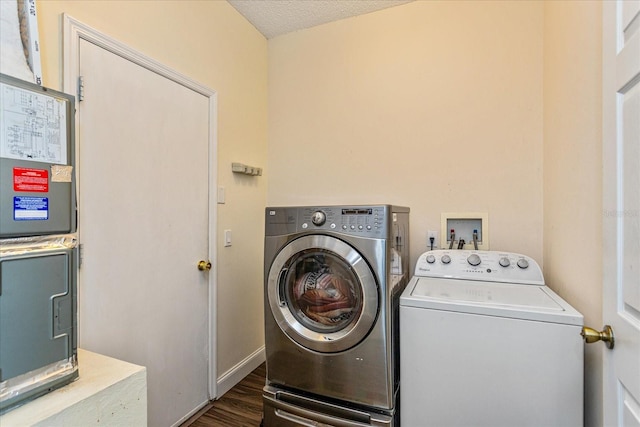 clothes washing area with dark hardwood / wood-style flooring, a textured ceiling, and washing machine and clothes dryer