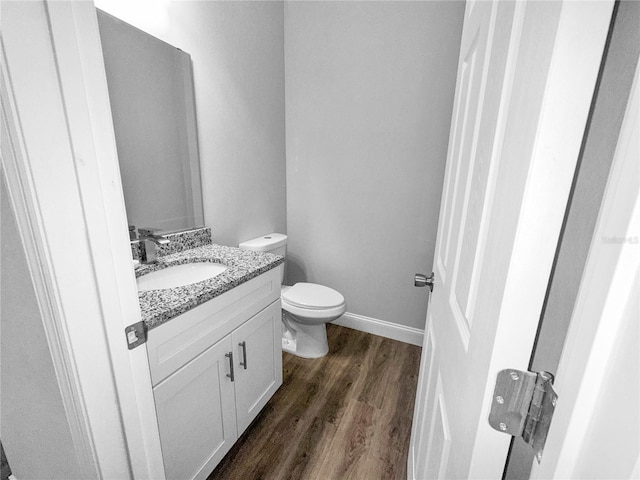 bathroom with hardwood / wood-style floors, vanity, and toilet