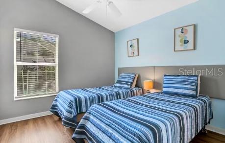 bedroom featuring dark hardwood / wood-style flooring, vaulted ceiling, and ceiling fan