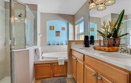 bathroom featuring tile patterned floors, vanity, and shower with separate bathtub