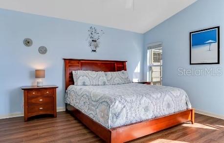 bedroom featuring hardwood / wood-style floors and vaulted ceiling