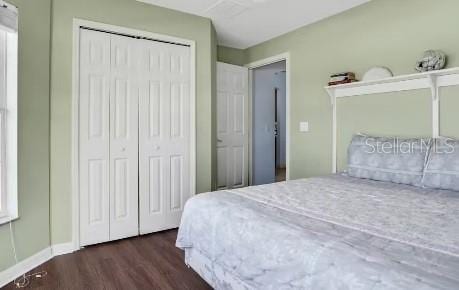 bedroom with dark hardwood / wood-style flooring and a closet