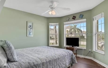 bedroom with ceiling fan and dark wood-type flooring