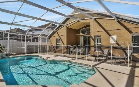 view of pool with a patio and glass enclosure