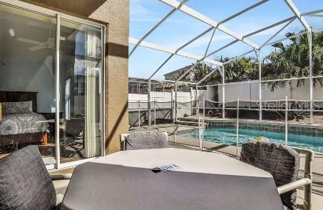 view of patio with a fenced in pool and glass enclosure