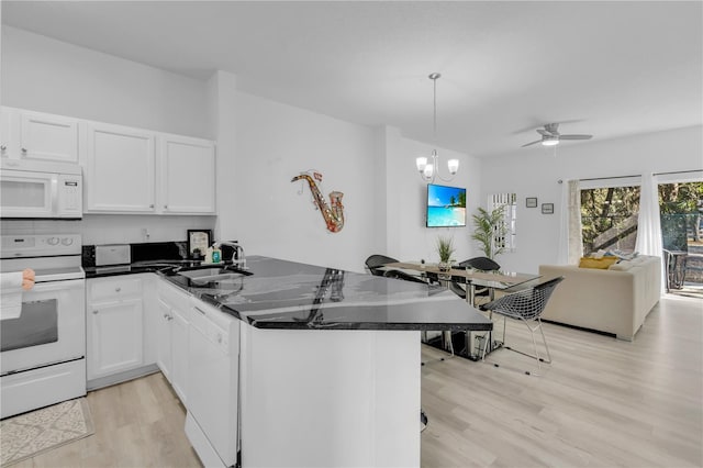 kitchen with sink, hanging light fixtures, kitchen peninsula, white appliances, and white cabinets