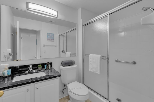 bathroom with vanity, toilet, and a shower with shower door