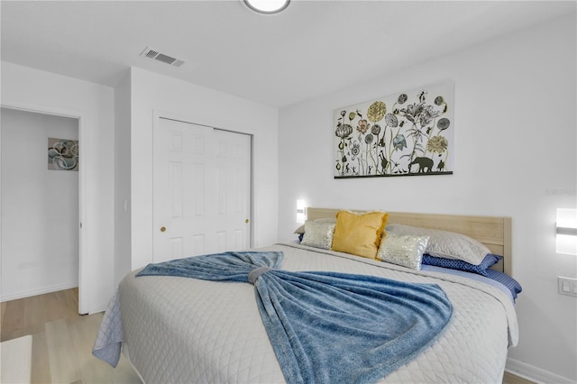 bedroom with light hardwood / wood-style flooring and a closet