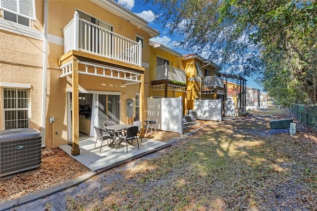 back of house featuring a patio area, central air condition unit, and a balcony