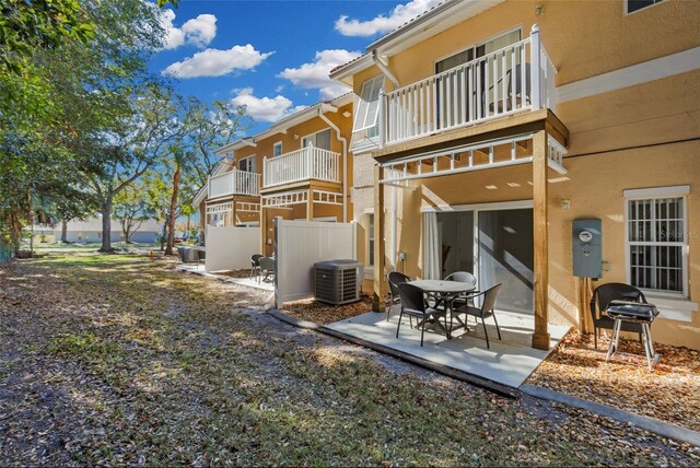 back of property with a patio area, a balcony, and central air condition unit