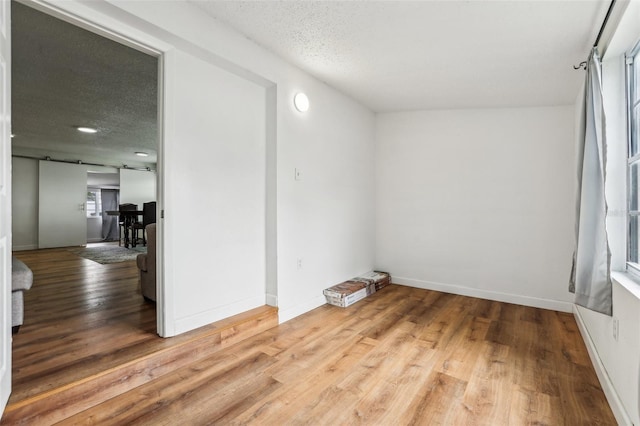 unfurnished room featuring hardwood / wood-style floors and a textured ceiling