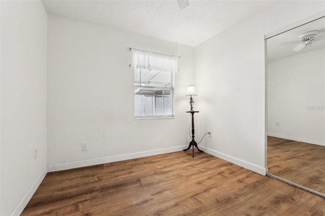 spare room with ceiling fan and wood-type flooring