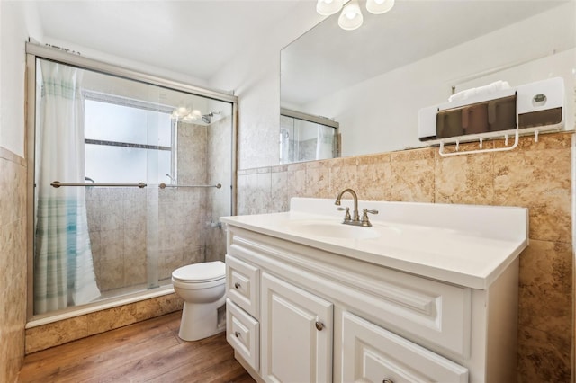 bathroom with hardwood / wood-style floors, vanity, tile walls, and toilet