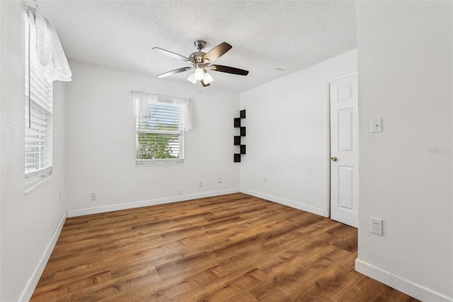 empty room with hardwood / wood-style floors, a textured ceiling, and ceiling fan