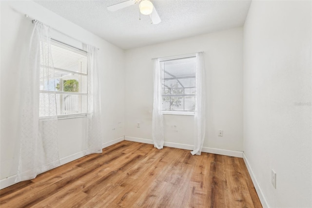 empty room with ceiling fan, light hardwood / wood-style floors, and a textured ceiling