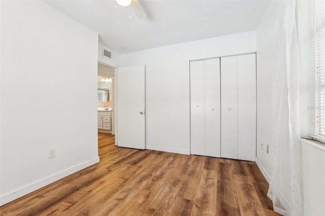 unfurnished bedroom featuring ceiling fan, a closet, and hardwood / wood-style floors