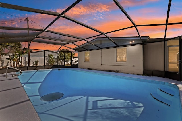 pool at dusk featuring glass enclosure