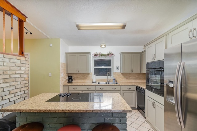 kitchen featuring sink, black appliances, a center island, and a kitchen bar