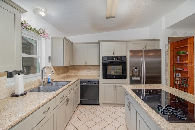 kitchen featuring sink, black appliances, vaulted ceiling, light tile patterned floors, and backsplash