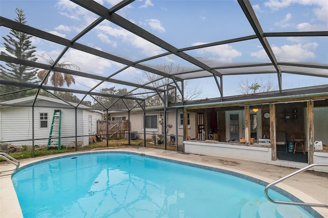 view of pool with a shed, a lanai, and a patio area