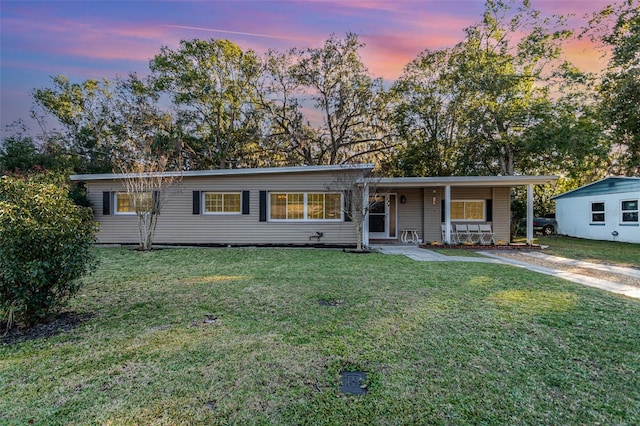 view of front of property with a porch and a yard