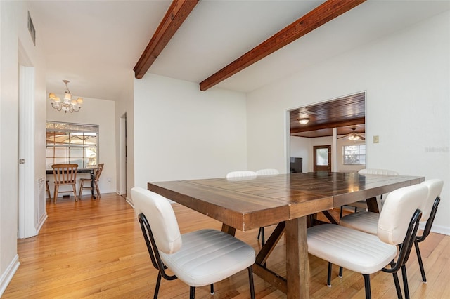 dining space featuring beamed ceiling, ceiling fan with notable chandelier, and light hardwood / wood-style flooring