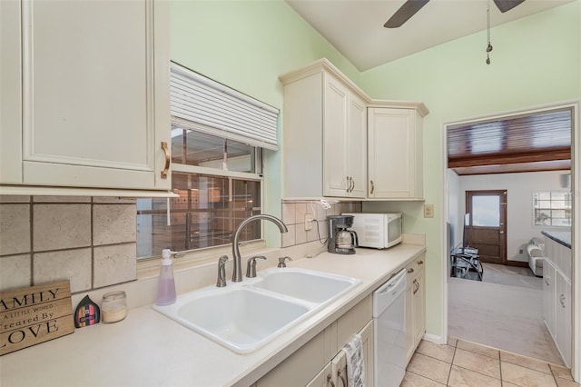 kitchen with ceiling fan, sink, backsplash, white appliances, and light carpet