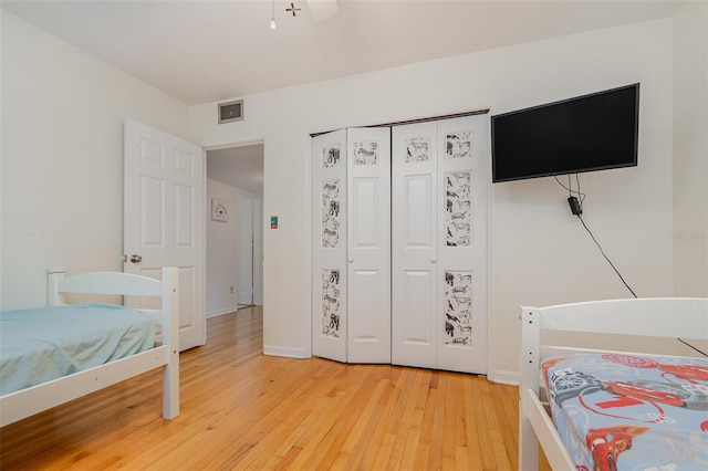 bedroom featuring ceiling fan, wood-type flooring, and a closet