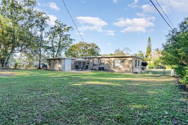 back of house featuring a lawn, a patio area, and central AC